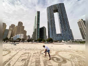 Sand artist Nathaniel Alapide draws on the beach in Dubai