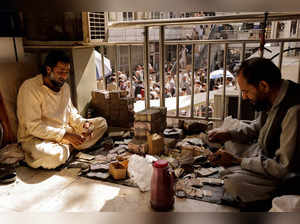 FILE PHOTO: Afghan currency exchange workers count money at a market in Kabul