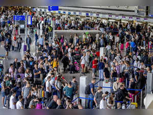 Passengers queue at check in counters at the international airport in Frankfurt,...