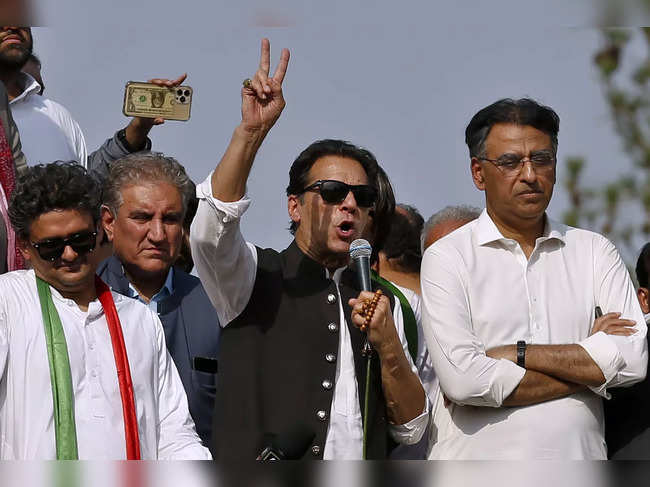 Supporters of Pakistan‚Äôs defiant former Prime Minister Imran Khan, center, add...