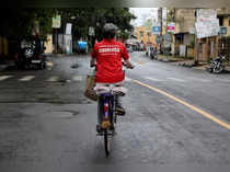 FILE PHOTO: A delivery worker of Zomato rides her bicycle along a road in Kolkata