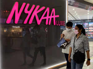 FILE PHOTO: People walk past a store of Nykaa, an Indian beauty products retailer, at a mall in New Delhi