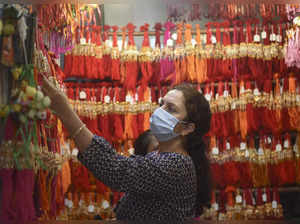 Mumbai: A woman checks 'rakhis' at a shop ahead of the Raksha Bandhan festival, ...