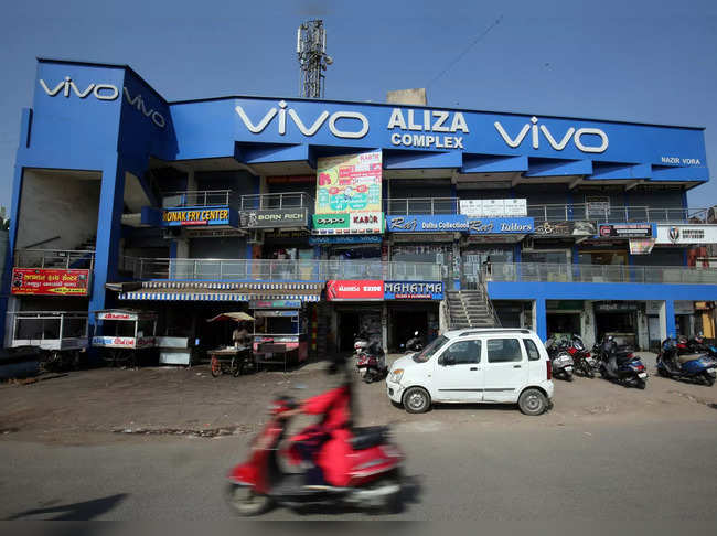 FILE PHOTO: A scooterist rides past a shopping complex with the billboard of Chinese smartphone maker Vivo in Ahmedabad