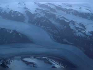 Glacial ice from the Greenland Ice Sheet flows around mountains into the ocean on the east coast of Greenland