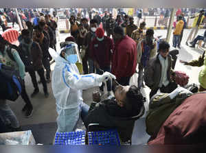 New Delhi: A health worker collects swab samples of passengers to conduct COVID-...