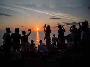 FILE PHOTO: Locals and tourists watch a sunset from Phuket Island's Phromthep Cape