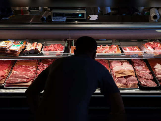 A customer looks at cuts of meat at a butcher shop in Manhattan, New York City