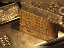 Gold inches higher as dollar softens ahead of Powell speech