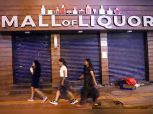 New Delhi, Aug 02 (ANI): People walk past a closed liquor shop at GTB Nagar, in ...
