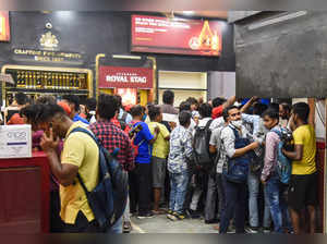 New Delhi: People buy liquor at a store at Azadpur area, in New Delhi. Delhi wil...