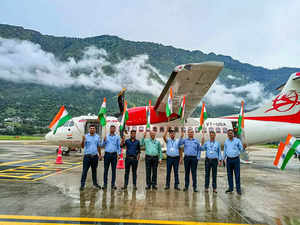 Kullu: Alliance Air officials pose for photos after landing of a newly inducted ...