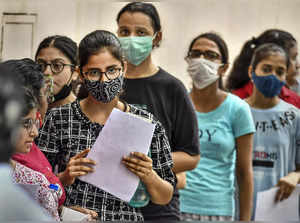 New Delhi: Candidates wait in a queue before appearing for the NEET UG exam, at ...