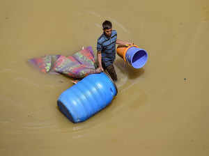 Bengaluru: A migrant shifts his belongings from a waterlogged locality after hea...