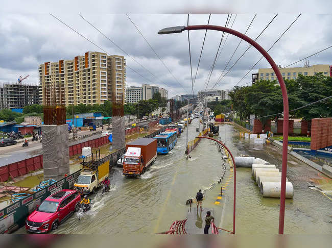 Bengaluru: Vehicles wade through the waterlogged Outer Ring Road after heavy mon...