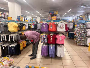 A man checks kids clothes in a mall in Abuja