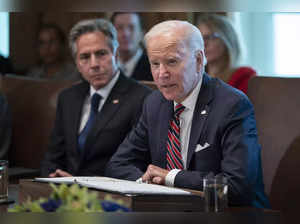 Secretary of State Antony Blinken listens as President Joe Biden speaks during a...