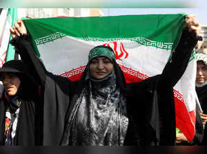 An Iranian pro-government woman holds the Iranian flag during a rally against the recent protest gatherings in Iran, after the Friday prayer ceremony in Tehran