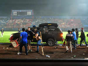 Supporters enter the field after the football match between Arema vs Persebaya at Kanjuruhan Stadium