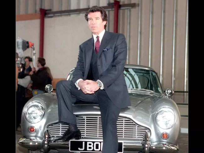 ​FILE PHOTO of Jan. 22, 1995​: Actor Pierce Brosnan, one of the actors who's played James Bond in the movies, poses for pictures while sitting on an Aston Martin, sportscar. Filming of his first Bond film, "Goldeneye", was taking place in a disused aerodrome in Watford, England.​