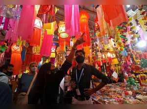 FILE PHOTO: People wearing face masks shop for lanterns at a market ahead of Diwali, in Mumbai