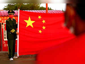 People attend the flag rising ceremony to celebrate China's national day at the base of the Taiwan People's Communist Party in Tainan