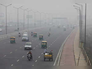 Vehicles are seen on a highway on a smoggy morning in New Delhi