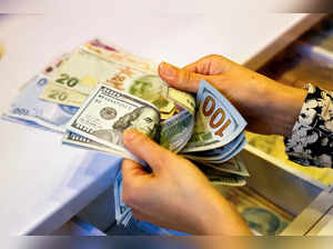 FILE PHOTO: A money changer counts U.S. dollar banknotes at a currency exchange office in Ankara