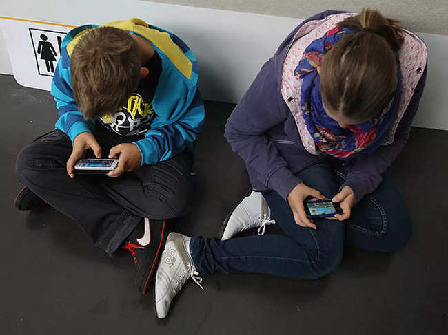 kids looking at smartphones