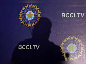 The shadow of a man falls on a backdrop with the logo of the India's cricket board BCCI before the start of a news conference to announce its cricket team's coach, in Mumbai,