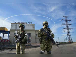 Russian troops guard an entrance of the Kakhovka Hydroelectric Station, a run-of...