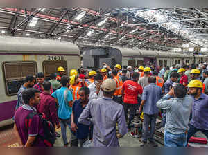 Mumbai: Central Railway employees and locals gather at a platform after a local ...