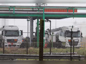 FILE PHOTO - A truck driver fills his fuel tanker at a TotalEnergie former oil refinery, in Mardyck
