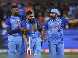 India's Virat Kohli, center, is escorted from the ground with teammates after wi...