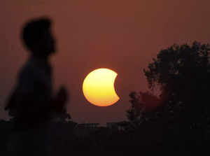 Patna: Birds fly as the moon partially covers the sun during the partial solar e...