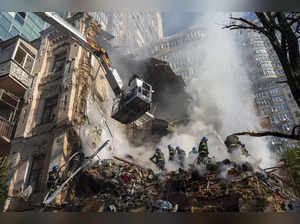 Firefighters work after a drone attack on buildings in Kyiv, Ukraine. Waves of e...