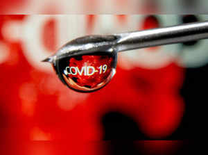 FILE PHOTO: The word "COVID-19" is reflected in a drop on a syringe needle in this illustration