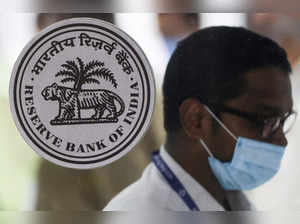 FILE PHOTO: A man walks past the logo of Reserve Bank of India (RBI) inside its headquarters in Mumbai