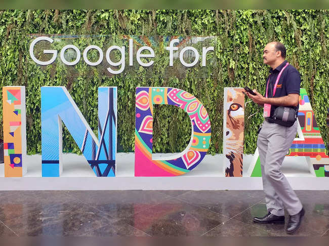 FILE PHOTO: A man walks past the sign of "Google for India", the company's annual technology event in New Delhi