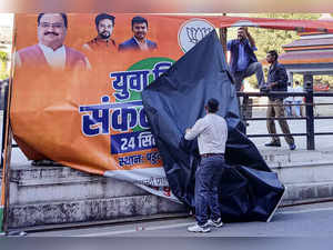 Mandi: Workers remove political banners ahead of the upcoming Himachal Pradesh A...