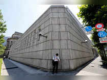 FILE PHOTO: A man looks at a mobile phone in front of the Bank of Japan building in Tokyo