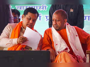 Varanasi: Uttar Pradesh Chief Minister Yogi Adityanath interacts with Union Mini...