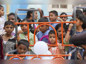 Mumbai: Children ride a swing during Children's Day celebrations organised at Ba...