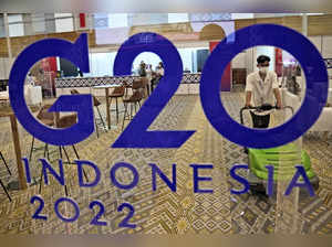 Nusa Dua: A worker is seen through a G20 logo as he cleans the media center of t...