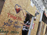 Woman paints on boarded up shop