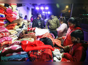 New Delhi, Dec 15 (ANI): People purchase winter garments at Palika Bazar, in New...