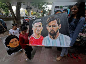 Students carry paintings depicting soccer players Diego Maradona, Cristiano Ronaldo and Lionel Messi, in Mumbai