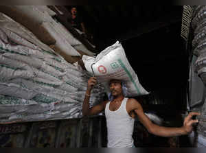 FILE PHOTO: A labourer carries a sack of sugar to load it onto a supply truck in Kolkata, India