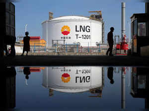 FILE PHOTO: Liquified natural gas(LNG) storage tank and workers are reflected in a puddle at PetroChina's receiving terminal at Rudong port in Nantong