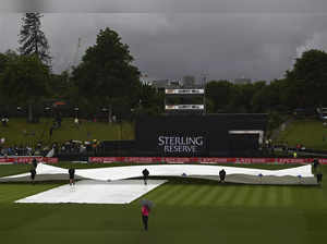 Ground staff pull covers onto the wicket during a rain delay in a one day intern...